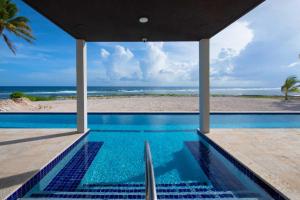 a swimming pool with a view of the beach at Wind Upon The Waves by Grand Cayman Villas & Condos in North Side