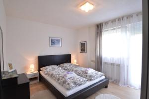 a bedroom with a bed with two lamps on it at Apartment Loza in Slunj