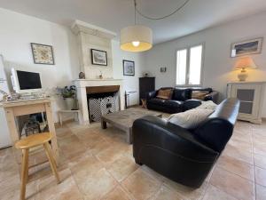 uma sala de estar com um sofá preto e uma lareira em Maison Saint-Martin-de-Ré, 3 pièces, 4 personnes - FR-1-246C-26 em Saint-Martin-de-Ré