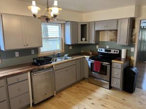 a kitchen with white cabinets and a sink and a stove at Water Front Oasis home in Norfolk