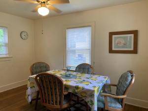 una sala da pranzo con tavolo, sedie e orologio di Residential Bungalow home a Norfolk