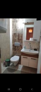 y baño con aseo blanco y lavamanos. en Sinope en Gokceada Town