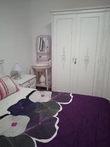 ein Schlafzimmer mit einem Bett mit einer lila Decke in der Unterkunft El patio de Marcos in La Recueja
