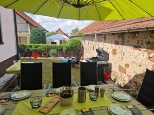 a table with a yellow table cloth and an umbrella at Karibu in Tiefenthal