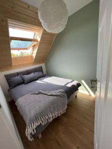 1 dormitorio con 1 cama en una habitación con ventana en Liwia Park Green House en Niechorze