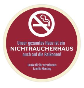 Un cartel rojo con un símbolo de no fumar. en Haus-Moselliebe-Charmantes-Fruehstuecks-Zimmer-mit-Balkon-und-Blick-auf-die-Mosel-Raucherfreihaus, en Ediger-Eller