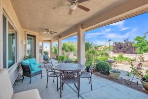 um pátio com uma mesa e cadeiras e uma ventoinha de tecto em Prescott Luxury Home near Golf Course and Airport home em Prescott Valley