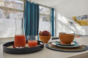 a table with a tray of juice and a bowl of fruit at Cosy renovated studio in heart of Paris XVieme in Paris