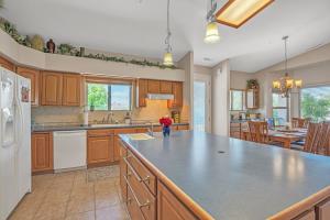 a kitchen with wooden cabinets and a large island at Prescott Luxury Home near Golf Course and Airport home in Prescott Valley