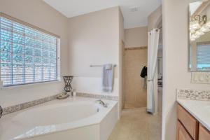 a white bathroom with a tub and a window at Prescott Luxury Home near Golf Course and Airport home in Prescott Valley
