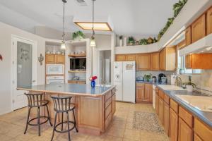 a kitchen with wooden cabinets and a island with bar stools at Prescott Luxury Home near Golf Course and Airport home in Prescott Valley