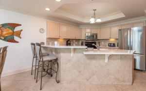 a kitchen with a island with bar stools at Phoenix IX 1105 condo in Orange Beach