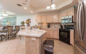 a kitchen with a sink and a refrigerator at Phoenix IX 1105 condo in Orange Beach