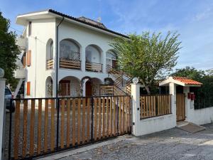 una casa blanca con una puerta y una valla en Mansarda seaview, en Senigallia