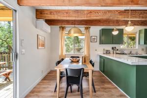 una cocina con armarios verdes y una mesa y sillas de madera. en Marina Beach Cabin - Dog-Friendly Home with Deck! home, en Groveland