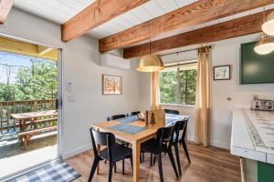 a dining room with a table and chairs and a balcony at Marina Beach Cabin - Dog-Friendly Home with Deck! home in Groveland