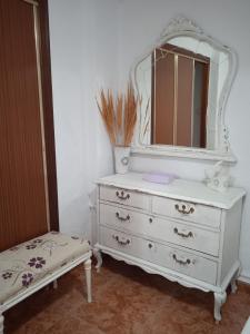 a white dresser with a mirror on top of it at El patio de Marcos in La Recueja