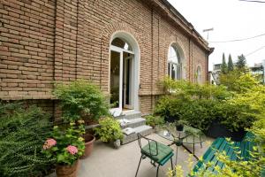 a brick building with a patio with chairs and plants at Funicular Inn Apartments in Tbilisi City