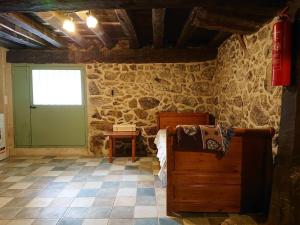 Zimmer mit einem Bett und einer Steinmauer in der Unterkunft Casa Pozo Tarama in Casavieja