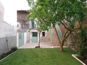 ein Haus mit einer grünen Tür und einem Baum in der Unterkunft Casa Pozo Tarama in Casavieja