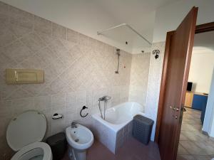 La salle de bains est pourvue d'une baignoire, de toilettes et d'un lavabo. dans l'établissement Appartamento bilocale 4 posti Olbia Codice IUN R3972, à Olbia
