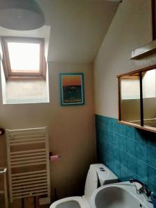 ein Bad mit einem WC, einem Waschbecken und einem Fenster in der Unterkunft Penty lothea in Quimperlé