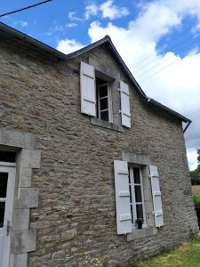 ein altes Backsteingebäude mit weißen Fensterläden in der Unterkunft Penty lothea in Quimperlé