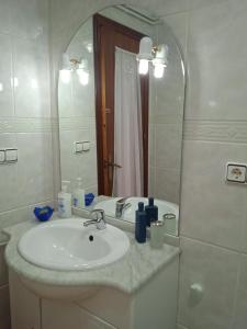ein Bad mit einem Waschbecken und einem Spiegel in der Unterkunft El patio de Marcos in La Recueja