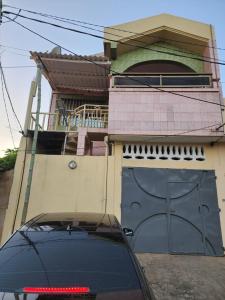 un'auto parcheggiata di fronte a una casa con garage di KADIDJA APARTMENTS & SUITES Akodessewa a Lomé