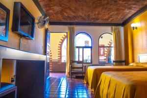 Habitación de hotel con 2 camas y TV en Hotel Villa Capri en Morelia