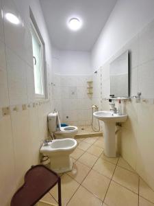a bathroom with a sink and a toilet and a mirror at Villa Velipoja in Velipojë +10 photos