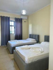 pokój z 3 łóżkami i oknem w obiekcie Villa Velipoja w mieście Velipoja