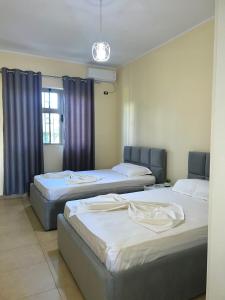 a room with three beds and a window at Villa Velipoja in Velipojë