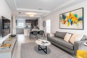 a living room with a couch and a table at Dahlia - The Designer Townhome in Lake Worth
