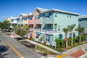 a row of houses on a street with a stop sign at Dahlia - The Designer Townhome in Lake Worth