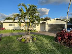 a palm tree in a yard in front of a house at The Sun House - 3 Bed, 2 Bath, Private Pool, Fire Pit, Huge Backyard in Fort Lauderdale