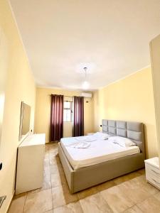 um quarto com uma cama grande e uma janela em Villa Velipoja em Velipojë