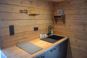 una cucina con lavandino e parete in legno di La Jo Welcome Home a Theux