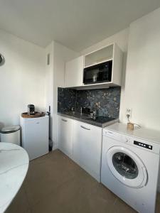 a kitchen with a washing machine and a sink at Joli studio entre Paris et Disneyland in Villemomble