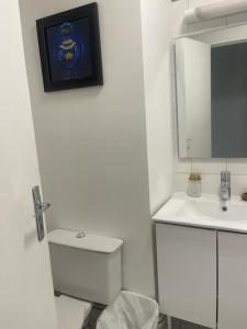 a bathroom with a toilet and a sink and a mirror at Joli studio entre Paris et Disneyland in Villemomble