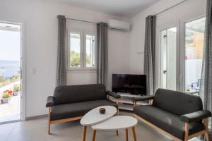 a living room with two couches and a tv at Cycladic Sunlight 2bedroom House in Krotiri