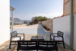 a patio with two chairs and a table on a balcony at Cycladic Sunlight 2bedroom House in Krotiri
