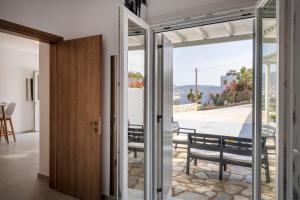 a glass door leading to a dining room with a view at Cycladic Sunlight 2bedroom House in Krotiri