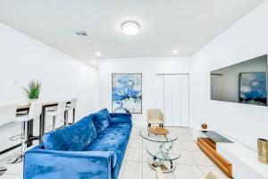 uma sala de estar com um sofá azul e uma mesa em Lavender at Aviara Lake Worth em Lake Worth