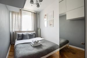 a bedroom with a bed with two towels on it at Wola Okopowa Luxury Apartment in Warsaw