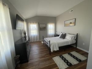 Schlafzimmer mit einem Bett mit weißer Bettwäsche und Holzböden in der Unterkunft The Penny Getaway 