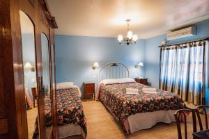 1 dormitorio con cama, mesa y espejo en Pousada Casa Rosa, en Canela