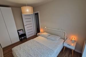 a bedroom with a bed and a night stand and a table at Piękny apartament z widokiem in Katowice