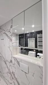 bagno con grande specchio e lavandino di Piękny apartament z widokiem a Katowice
