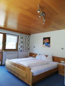 ein Schlafzimmer mit einem großen Bett und einer Holzdecke in der Unterkunft Haus Ritter 286 in Schoppernau